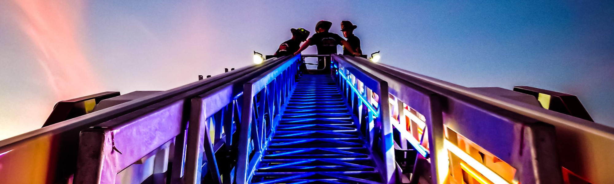 Three firefighters on the top of Truck 50's ladder